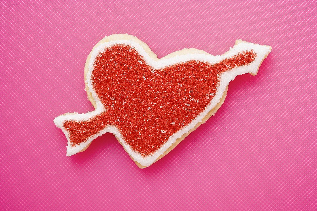 Heart-shaped biscuit with arrow, decorated with red sugar