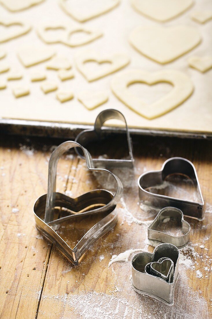 Heart-shaped biscuit cutters and cut-out biscuits