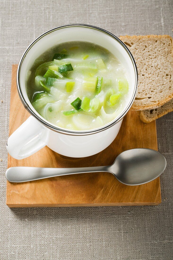 Leek cream soup with bread and spoon