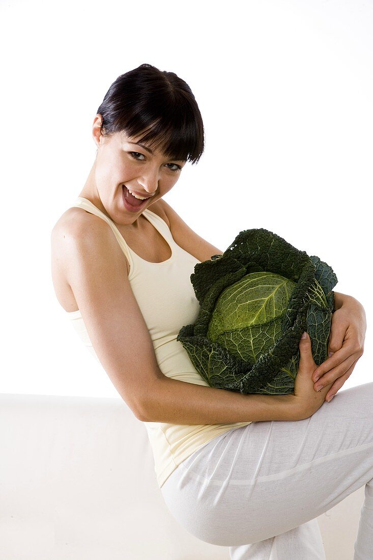 Young woman holding a savoy cabbage