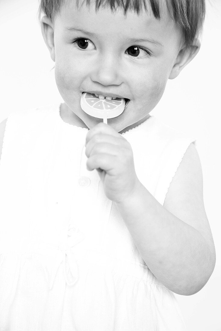 Small girl sucking a lollipop