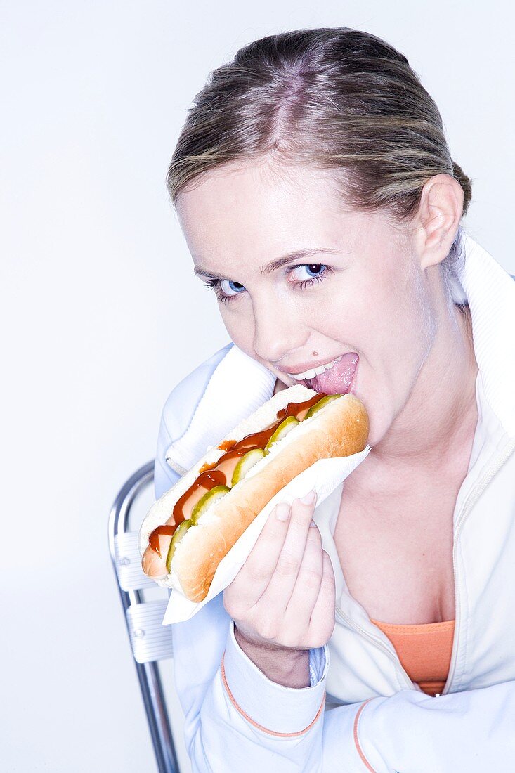 Junge Frau isst Hot Dog