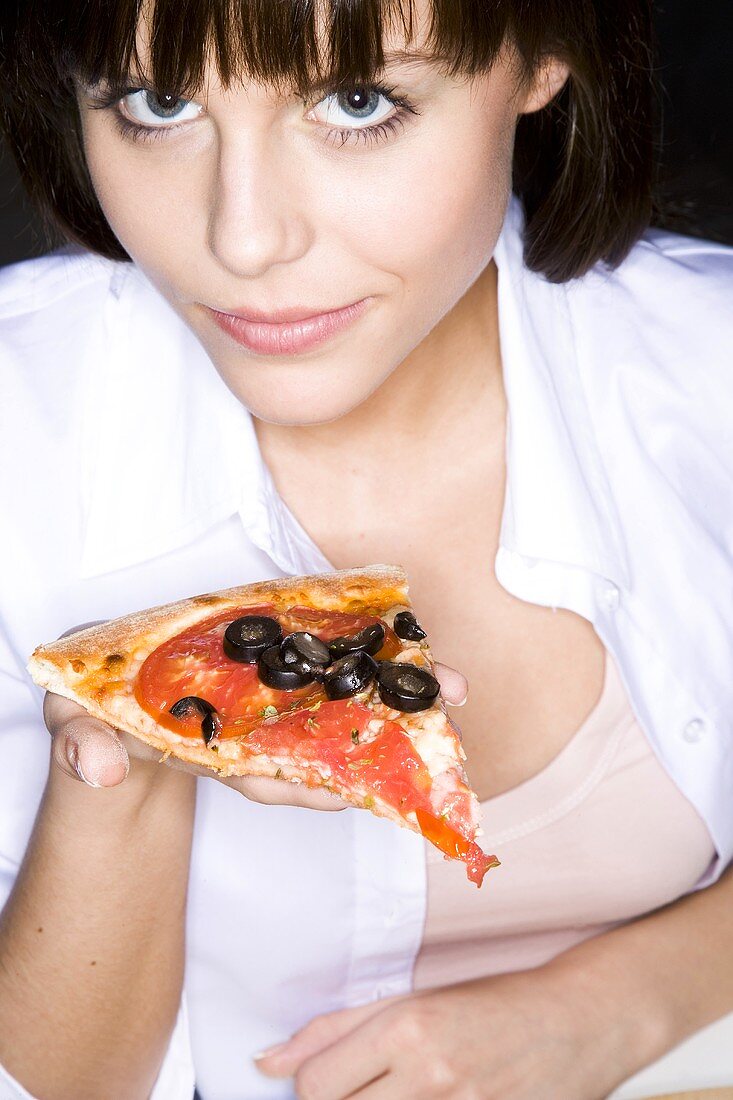 Young woman holding a slice of pizza