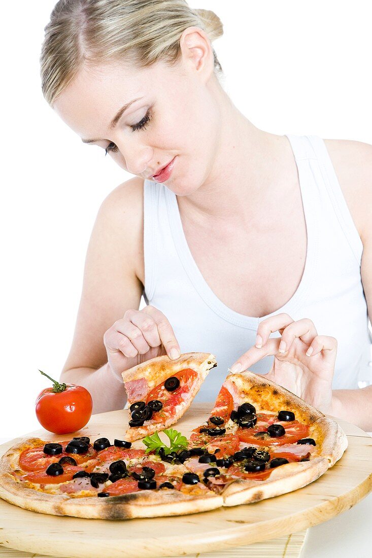 Young woman taking a slice of pizza