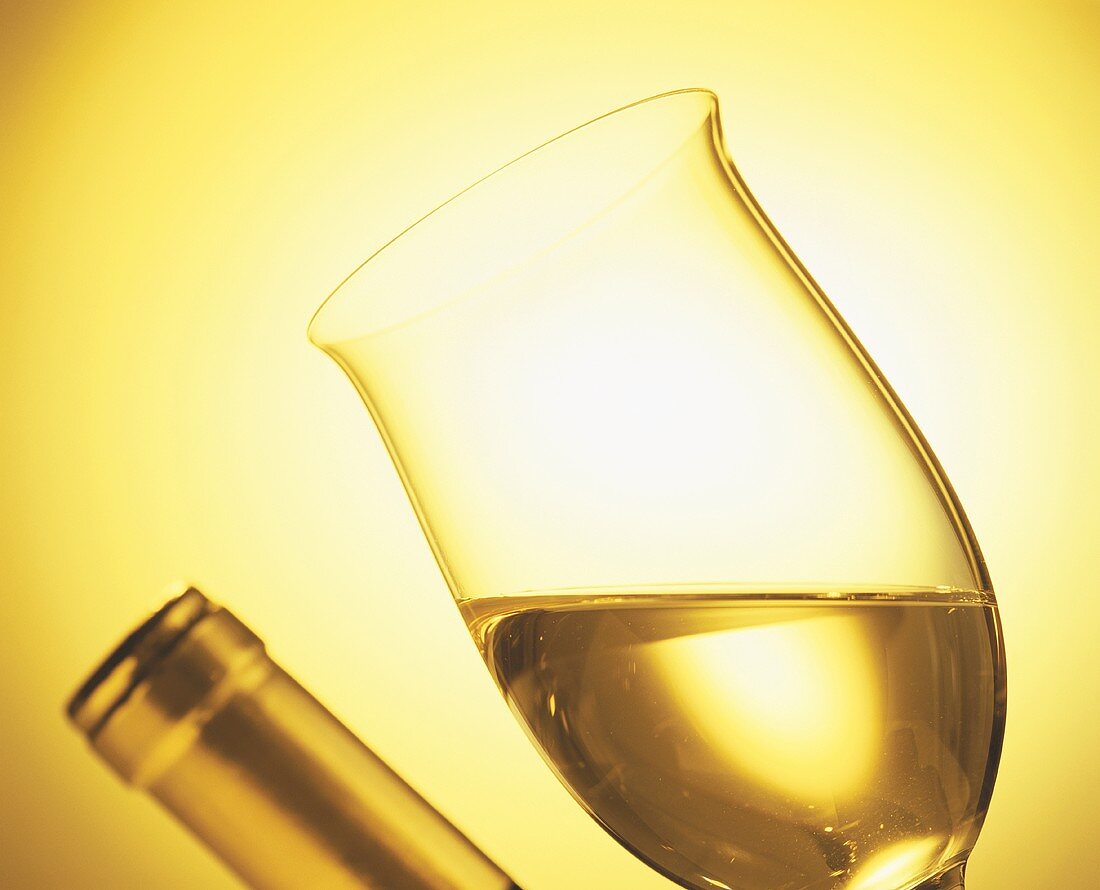 Glass of white wine and bottleneck