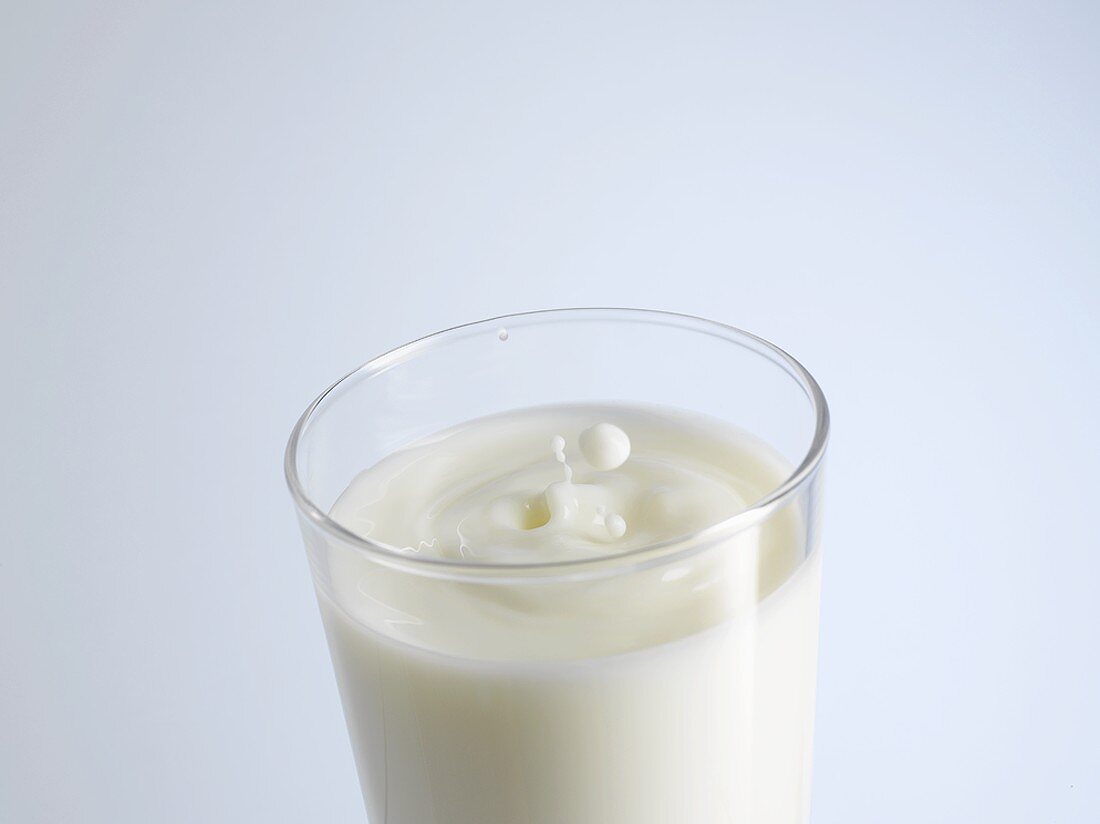 Ein Glas Milch mit Milchtropfen