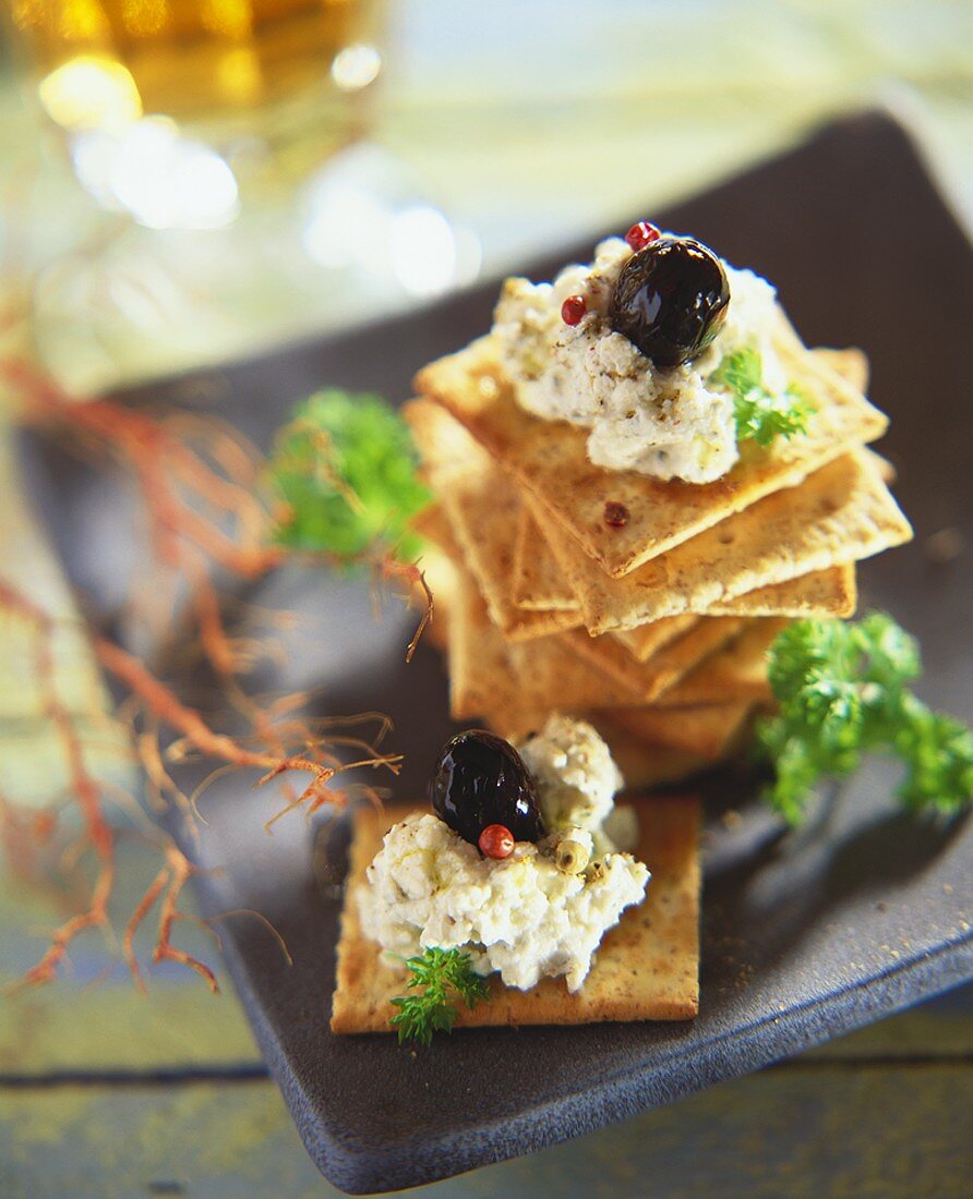 Aubergine cream and black olives on crackers