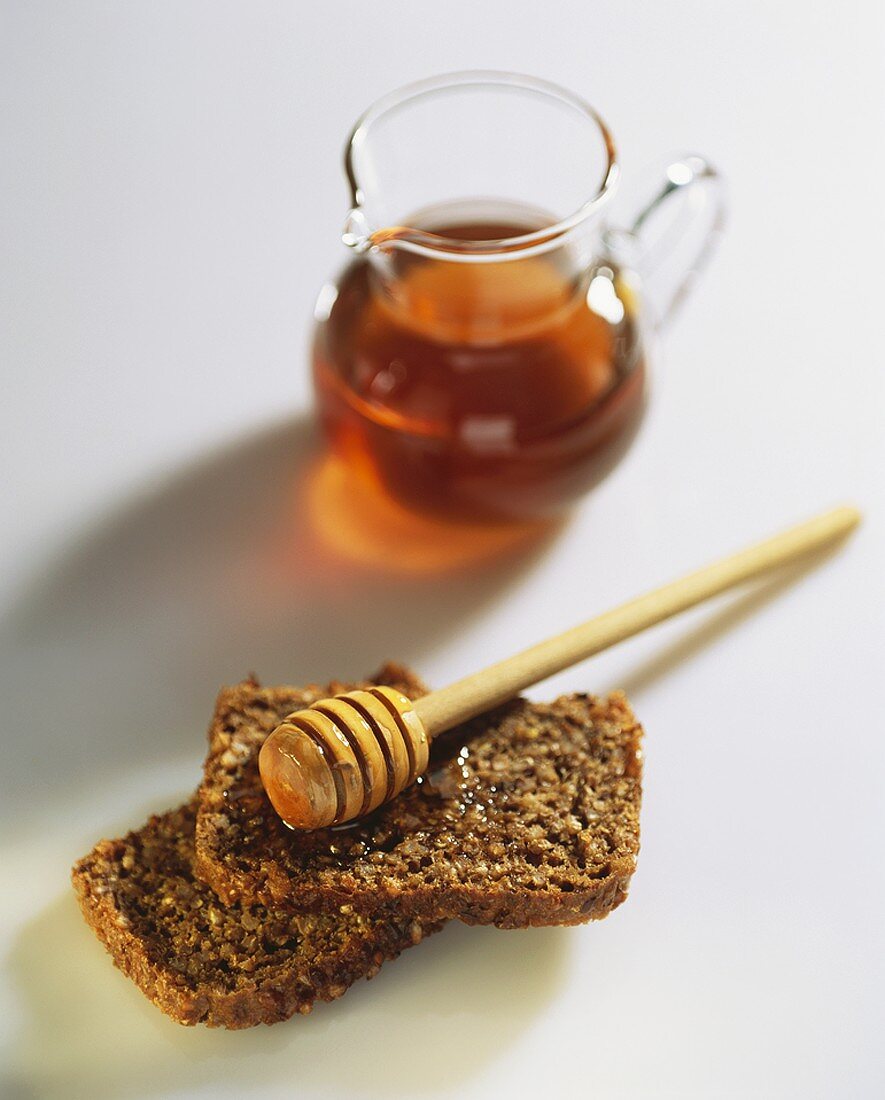 Wholegrain bread with honey and honey dipper