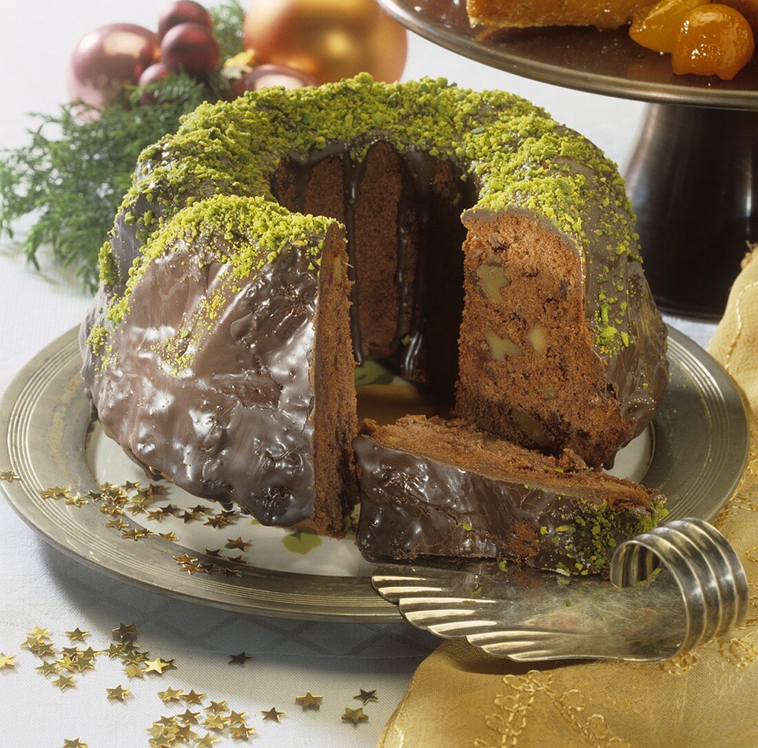 Chocolate-covered ginger cake with nuts, partly sliced