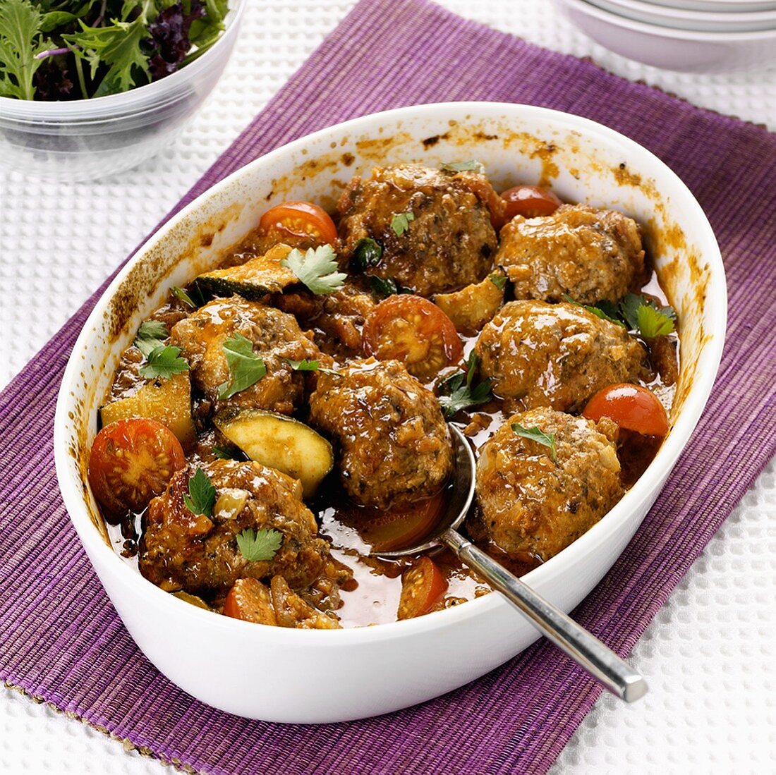 Oven-baked lamb meatballs with tomatoes and courgettes