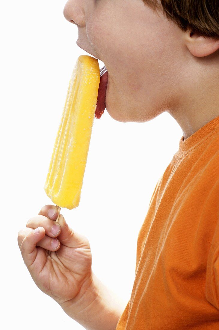 Boy enjoying an orange ice lolly