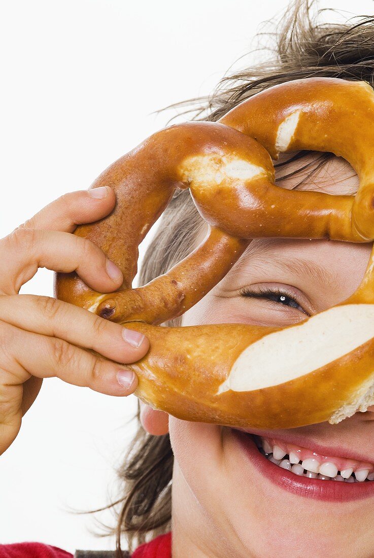Boy looking through a pretzel