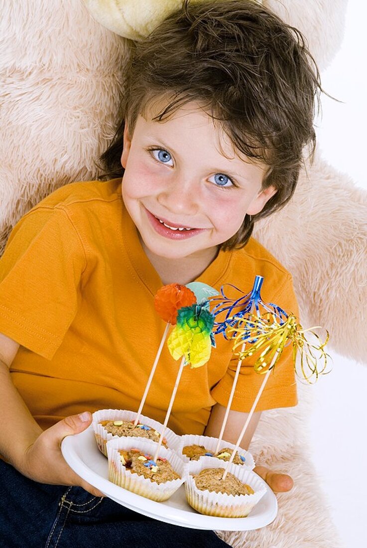 Boy holding a tray of muffins