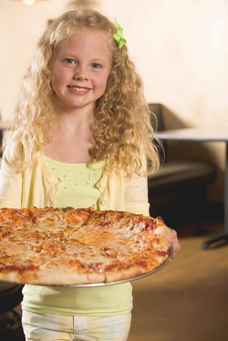 Blondes Mädchen hält eine Pizza