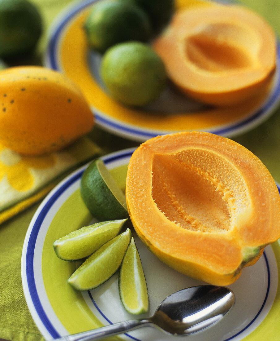 Halved papaya with lime wedges