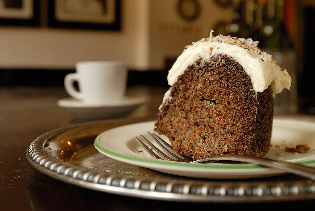 A piece of carrot and nut cake with cream topping