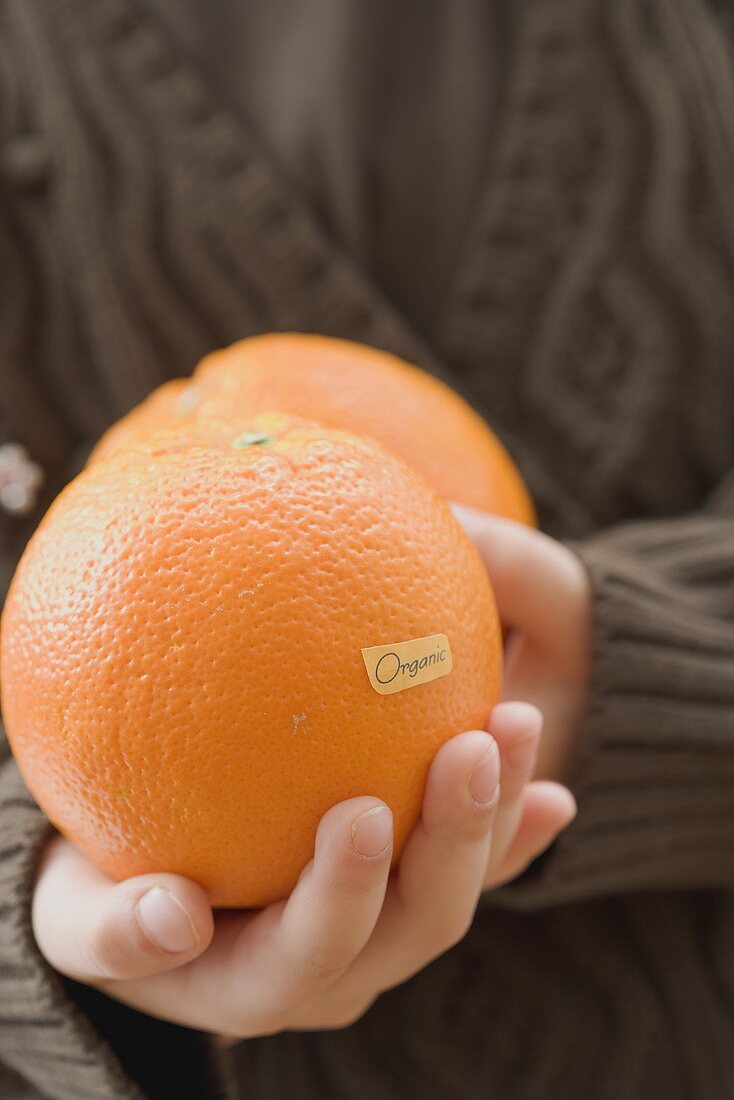 Girl holding organic oranges