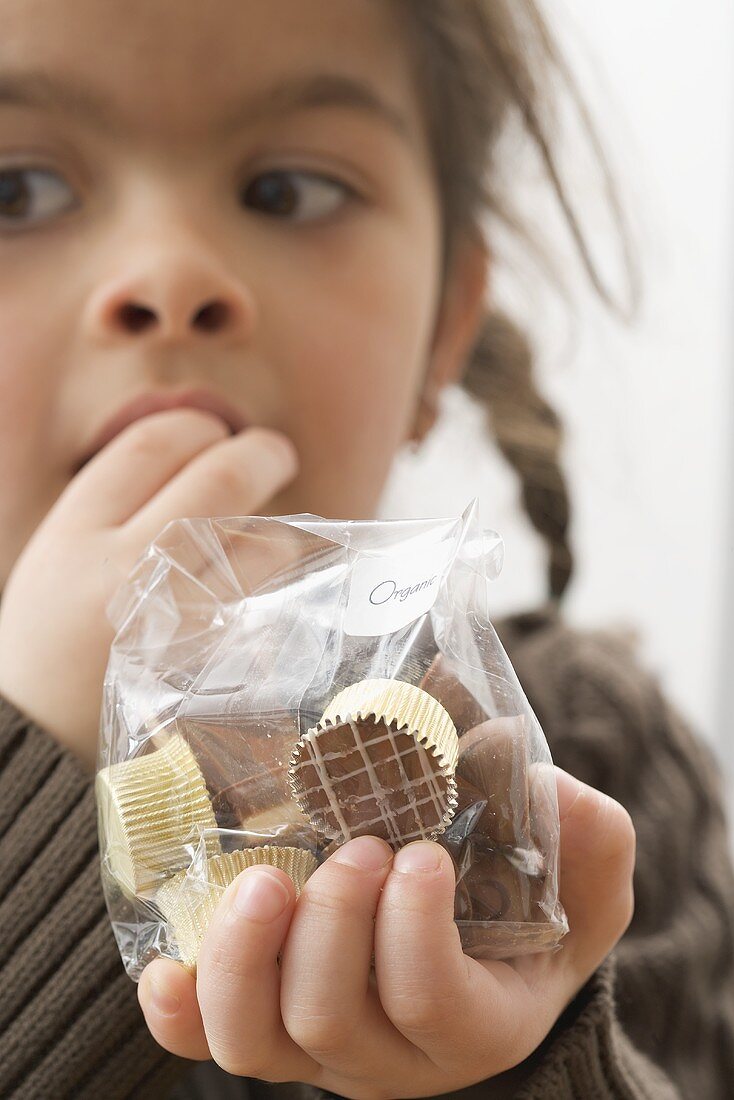 Girl eating chocolates out of a bag