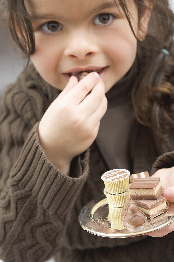 Mädchen beisst in eine Praline