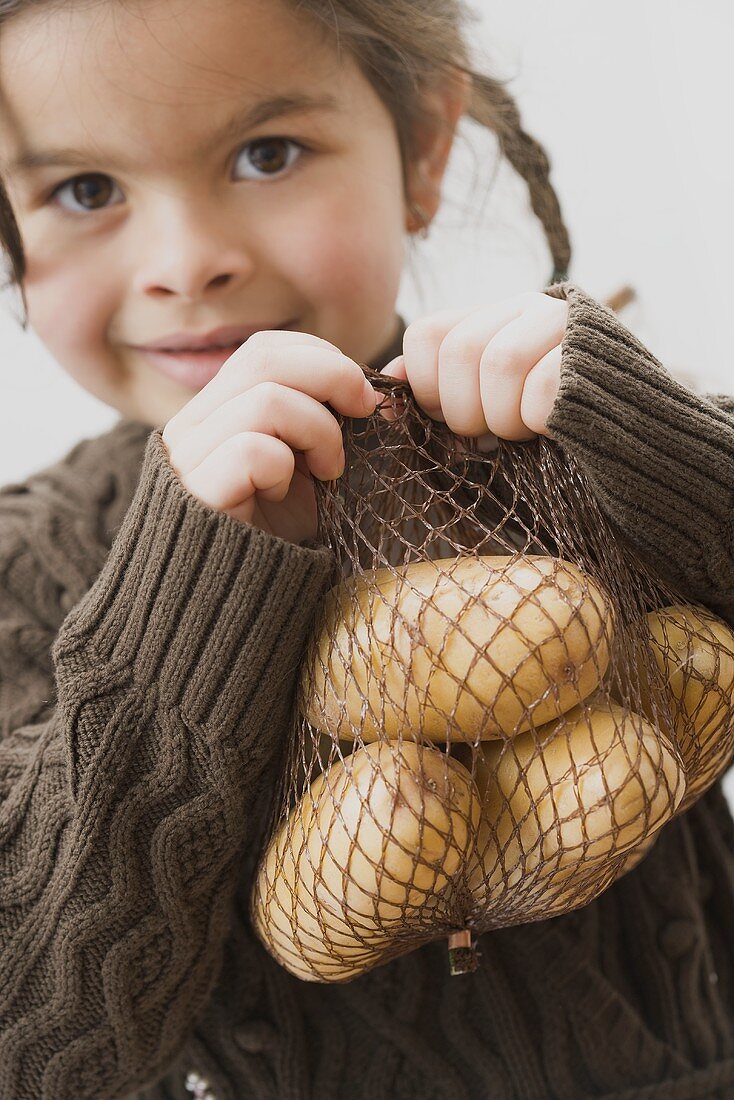 Mädchen mit einem Netz Kartoffeln