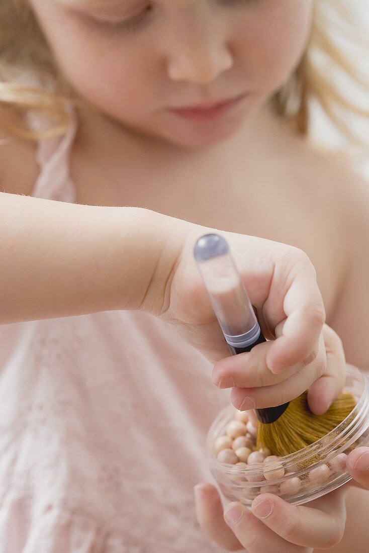 Girl holding powder pearls and brush