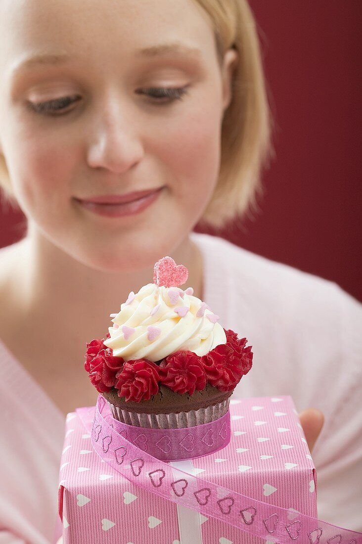 Young woman with cupcake and Valentine's Day gift