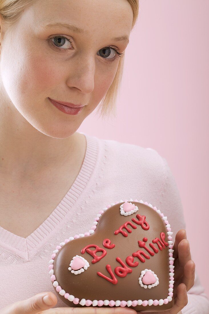 Young woman with a chocolate heart for Valentine's Day