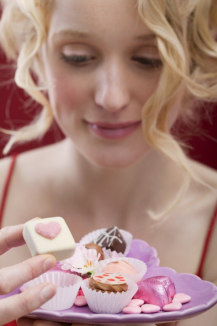 Young woman eating chocolates and sweets