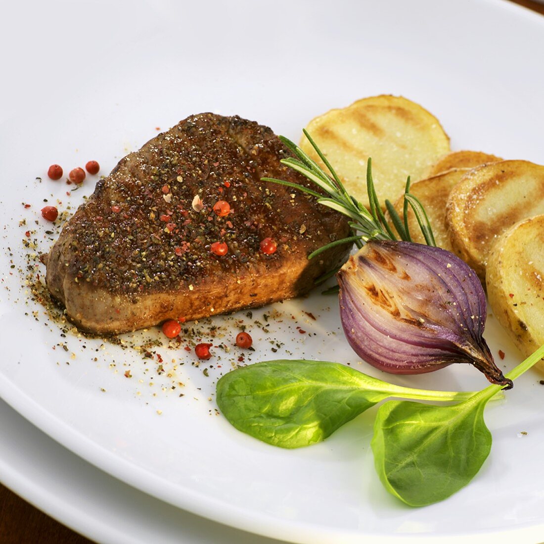 Pfeffersteak mit Kartoffelscheiben und Zwiebel