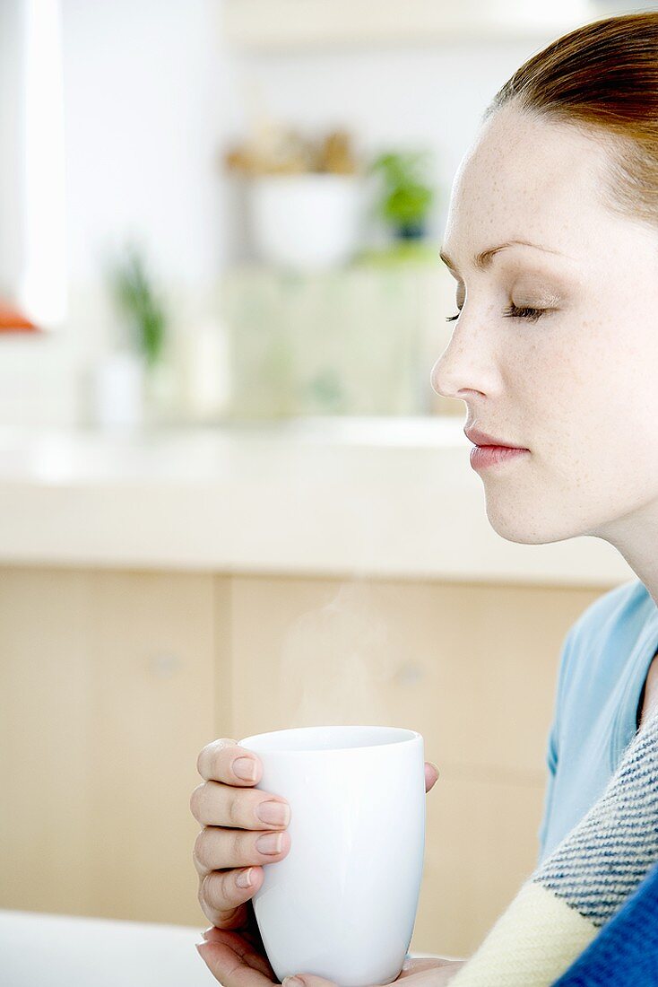 Junge Frau hälte eine Tasse Kaffee in der Hand