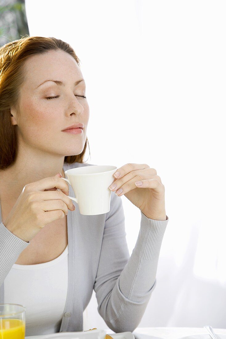 Junge Frau trinkt Frühstückskaffee