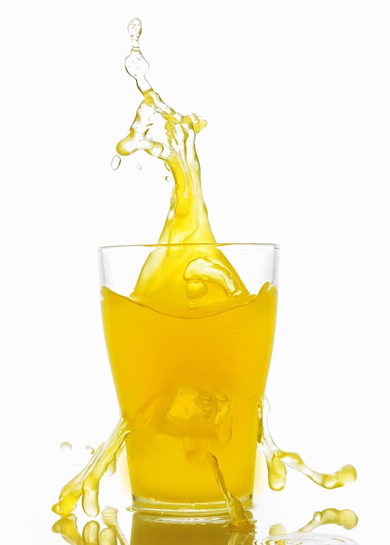 Orangenlimonade spritzt aus dem Glas