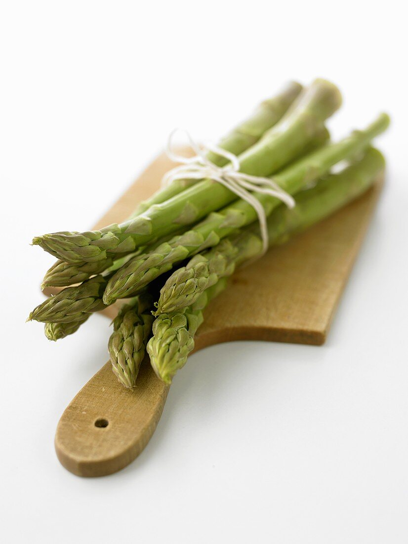Green asparagus on chopping board
