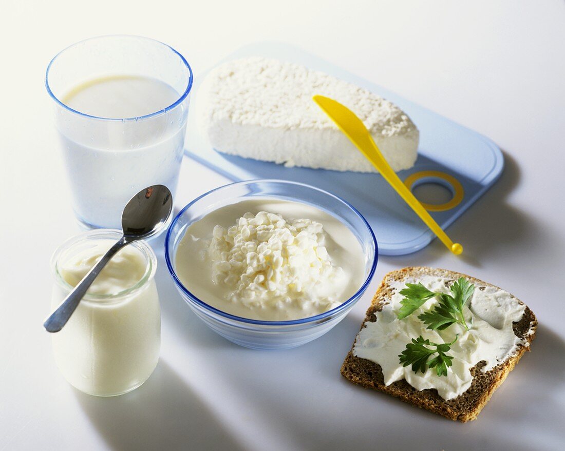 Various dairy products & a slice of bread with soft cheese