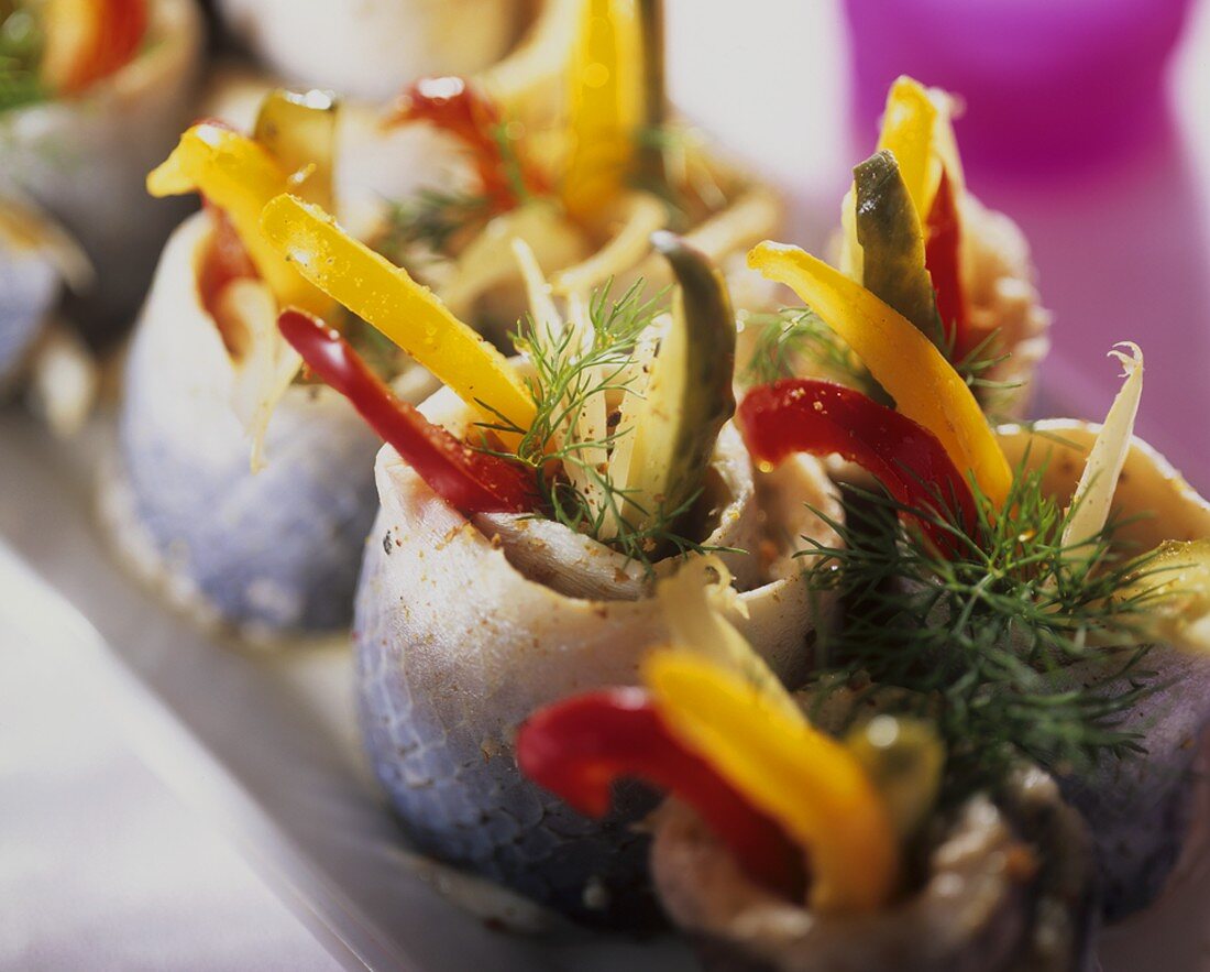 Herring rolls filled with cucumber, peppers and onions