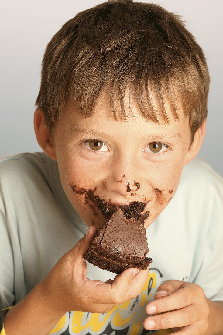 Junge isst ein Stück Schokoladenkuchen