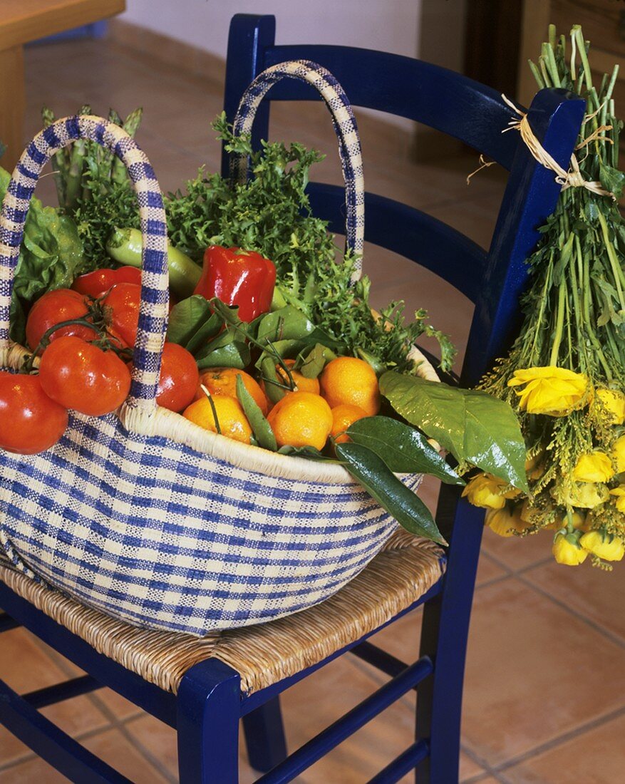 Tasche mit frischem Gemüse und Obst auf einem Stuhl