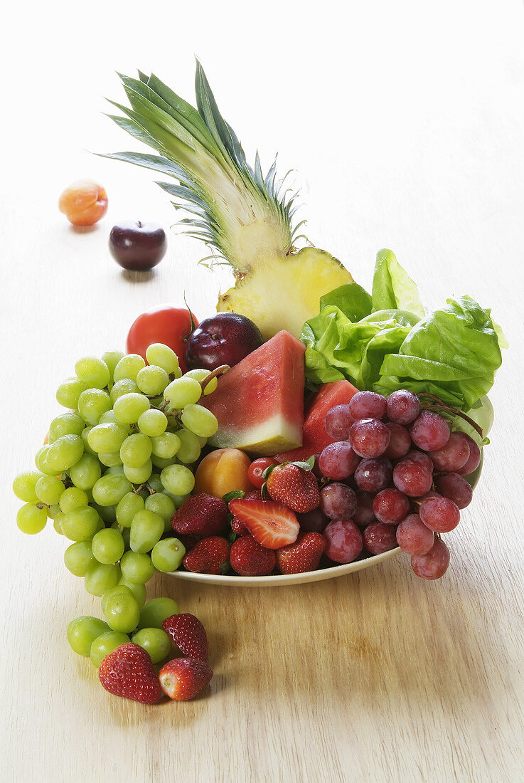 Früchteteller mit Weintrauben, Melone, Ananas, Erdbeeren etc.