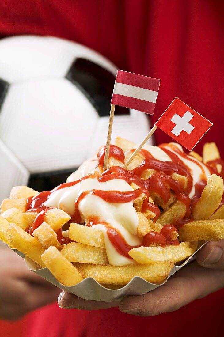 Chips with ketchup and mayonnaise, flags and football