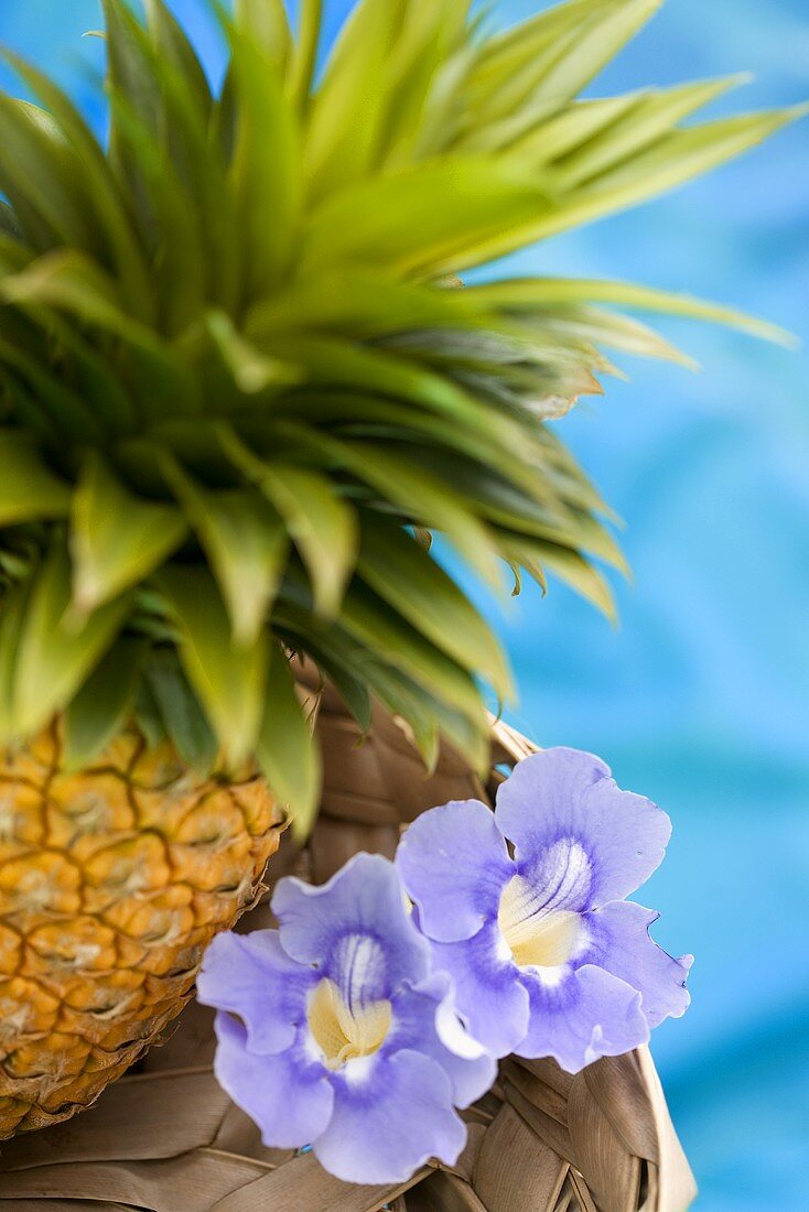 A pineapple with tropical flowers