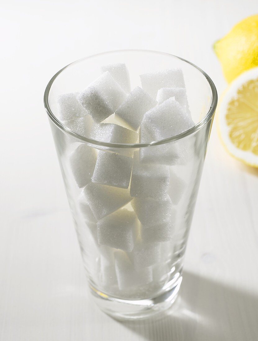 Sugar cubes in tumbler, lemons in background