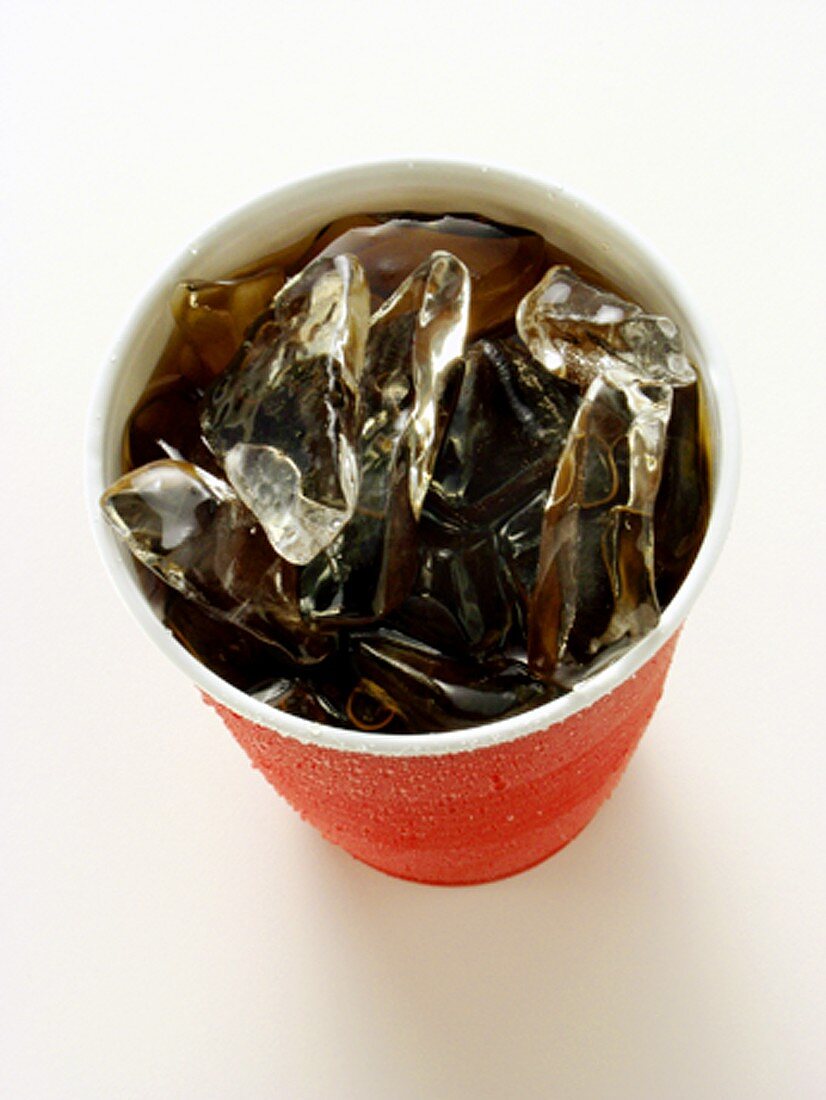 Cola mit Eiswürfeln im roten Plastikbecher