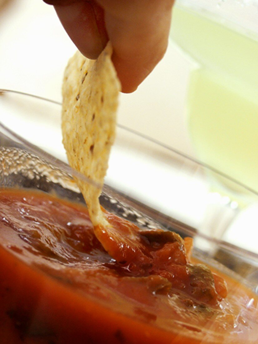 Tortillachip in Salsa dippen