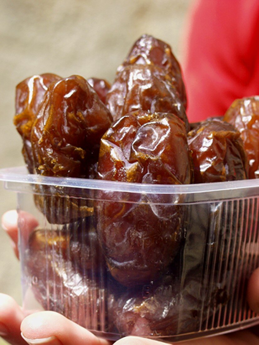 Holding Wrapped Dates in a Plastic Container