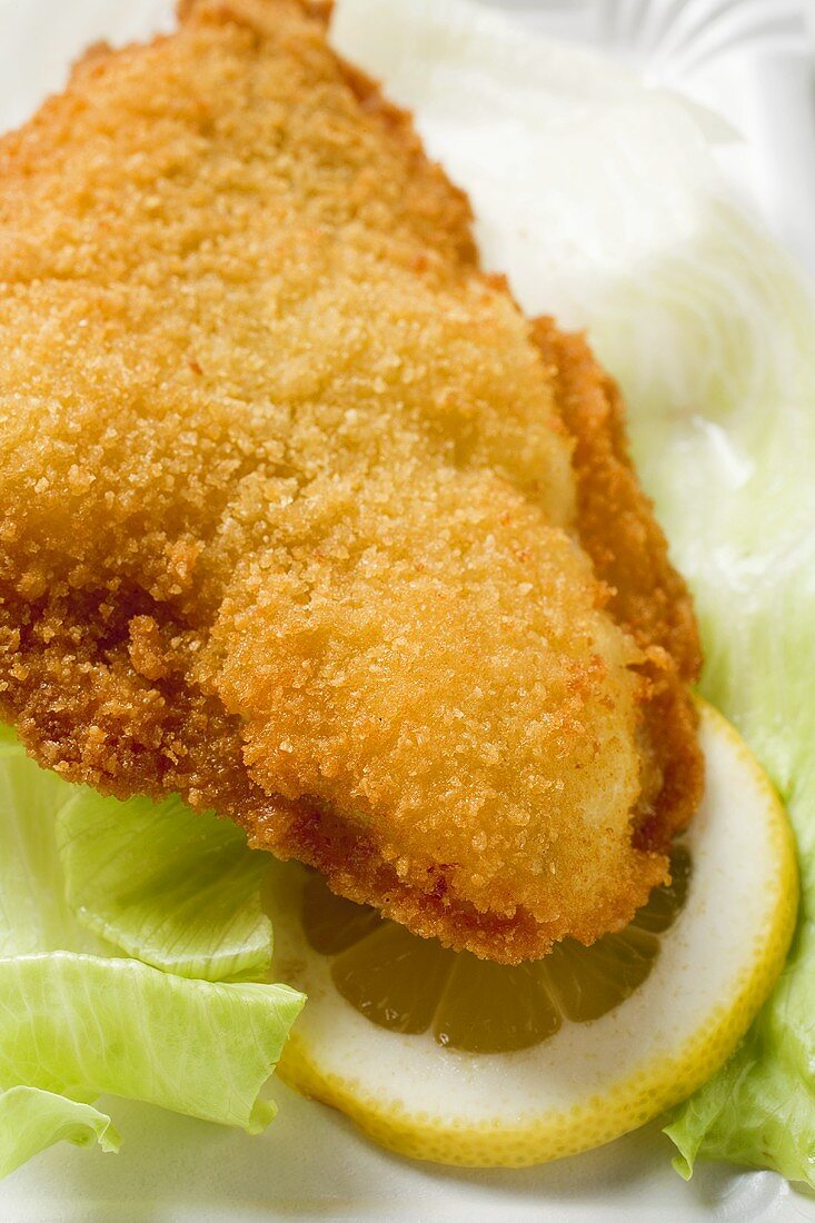 Fish nugget with lettuce leaf and slice of lemon