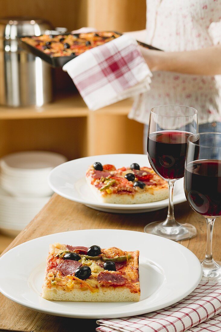 Pizza and red wine for two on table