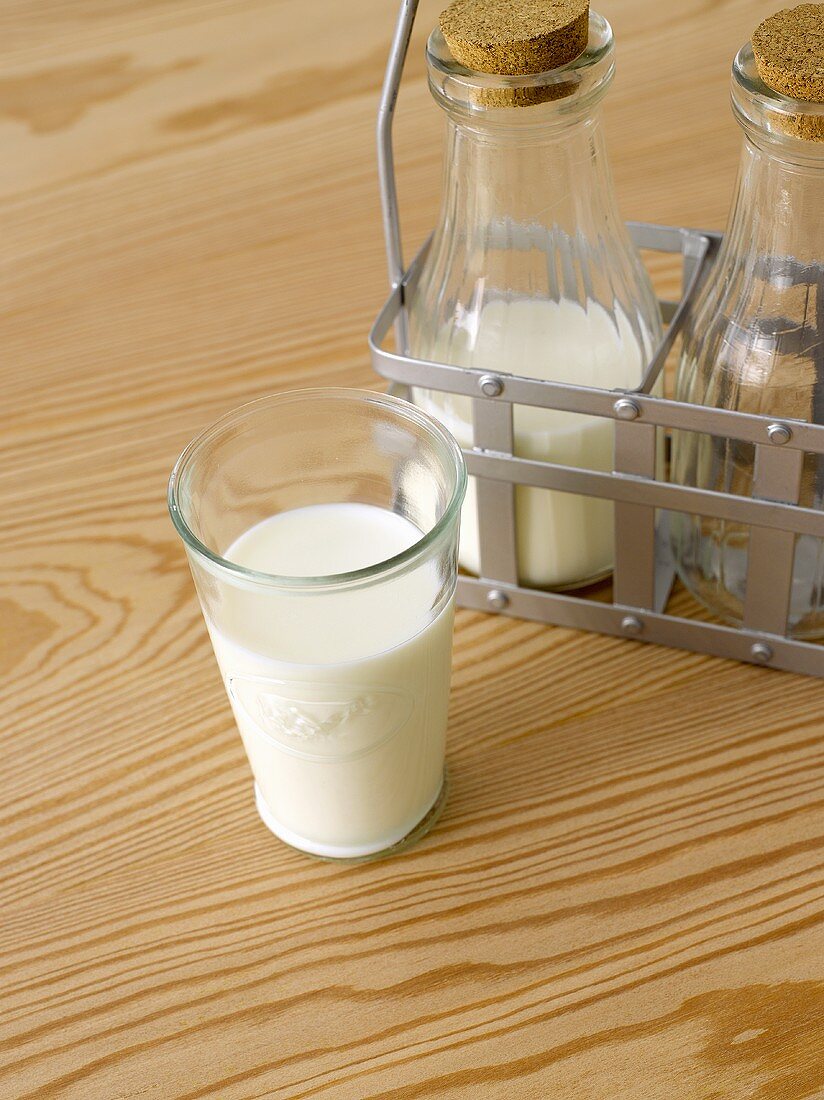 A glass of milk and milk bottles