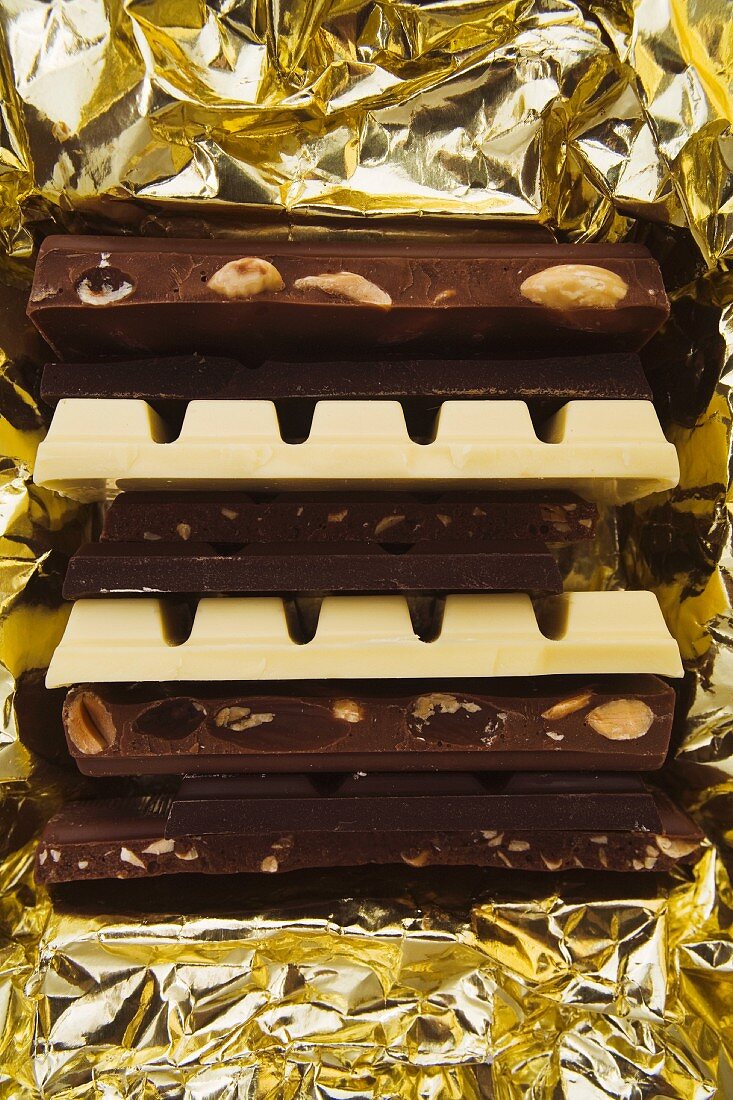 Bars of dark and white chocolate on gold foil