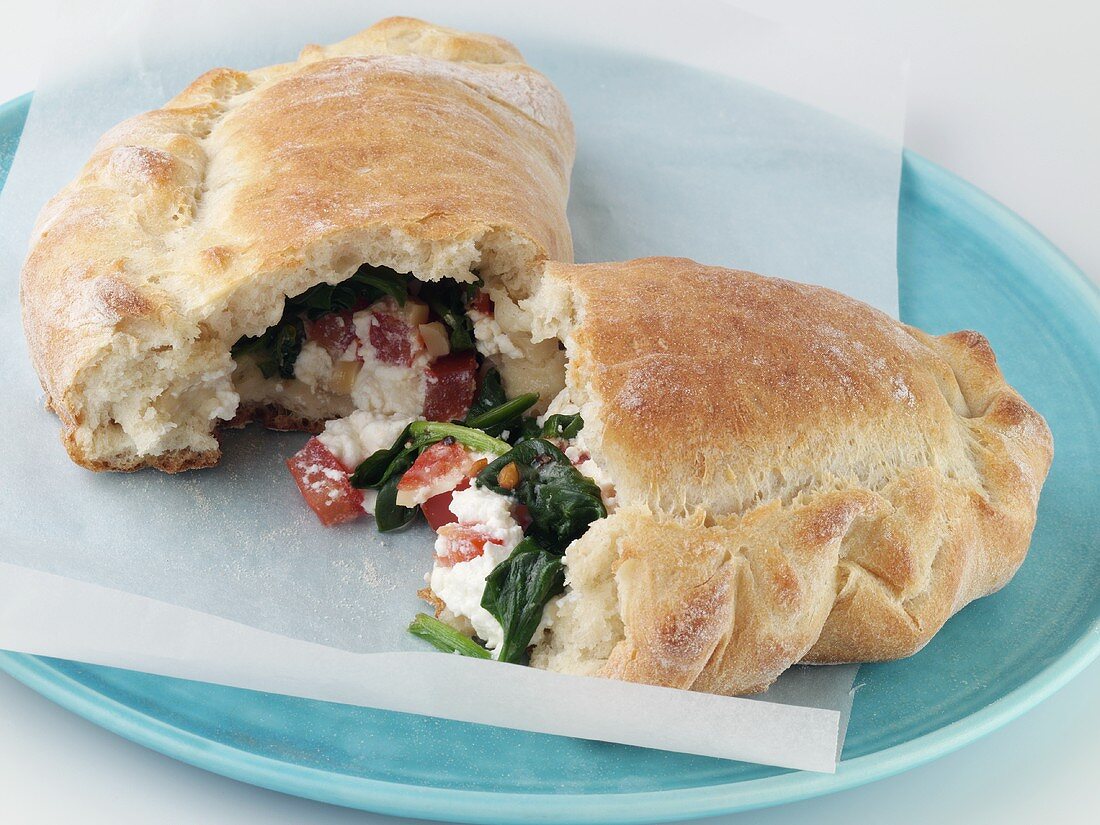Spinach and Ricotta Calzone; Halved on Blue Plate