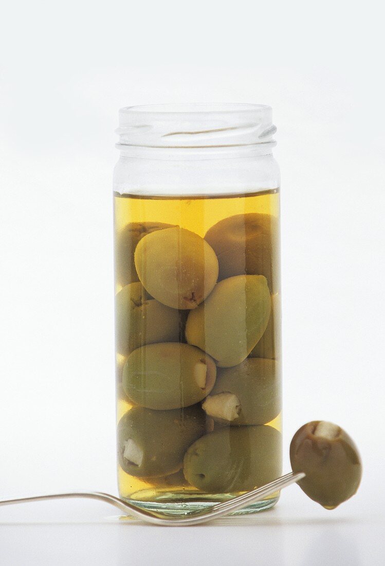 Gefüllte grüne Oliven im Glas